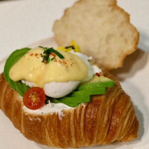 A refined twist on a classic—golden croissant paired with soft poached eggs and creamy hollandaise, delivering a light yet indulgent bite.